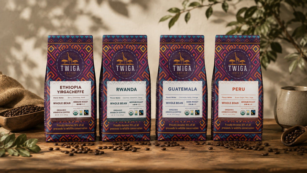 Four Twiga Coffee 12 oz whole bean bags, Ethiopia Yirgacheffe, Rwanda, Guatemala and Peru, standing on a wooden table with scattered coffee beans